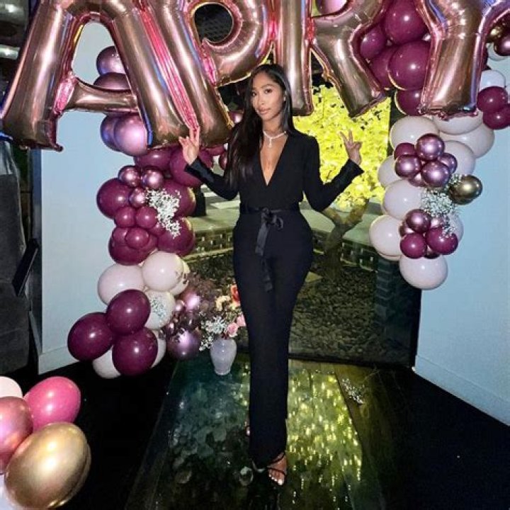 Apryl wearing a black coat and pant.