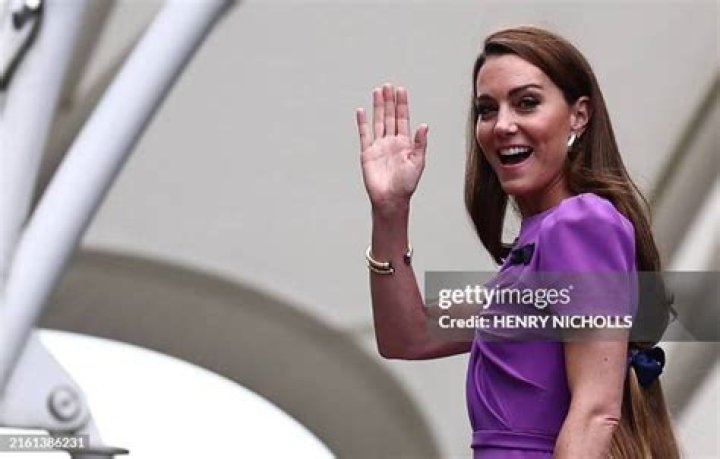 Catherine Middleton waves to the crowds as her sister and Maid of Honour Pippa Middleton holds her dress before walking in to the Abbey to attend t...