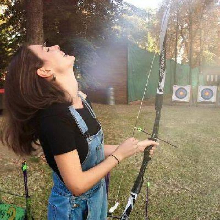 Genevieve Gaunt&nbsp;laughing while holding a bow and arrow