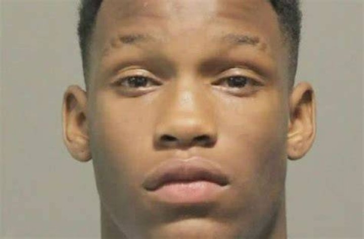 Marcus Cooper Jr. doesn't look happy in the picture as he is standing in front of a grey background.